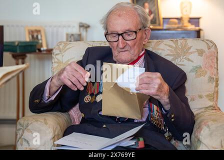 Vizeadmiral Sir Thomas Baird aus Symington in Ayrshire öffnet Karten, während er seinen 100. Geburtstag feiert. Sir Thomas nahm 41 Jahre in der Marine an den arktischen Konvois Teil, die von Großbritannien zu Häfen im äußersten Norden der Sowjetunion segelten, als eine Geste der Unterstützung der Alliierten, als Hitler gegen einen mit Stalin geschlossenen nichtangriffvertrag verstieß. Bilddatum: Freitag, 17. Mai 2024. Stockfoto