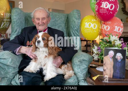 Vizeadmiral Sir Thomas Baird aus Symington in Ayrshire feierte seinen 100. Geburtstag mit seinem Hund Victoria. Sir Thomas nahm 41 Jahre in der Marine an den arktischen Konvois Teil, die von Großbritannien zu Häfen im äußersten Norden der Sowjetunion segelten, als eine Geste der Unterstützung der Alliierten, als Hitler gegen einen mit Stalin geschlossenen nichtangriffvertrag verstieß. Bilddatum: Freitag, 17. Mai 2024. Stockfoto