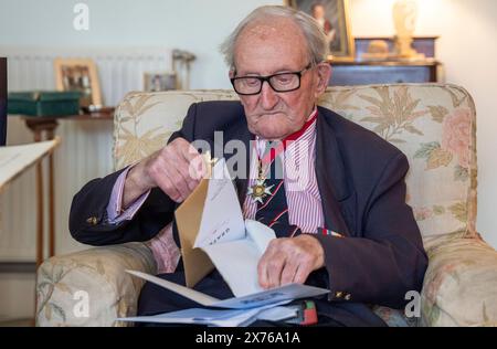 Vizeadmiral Sir Thomas Baird aus Symington in Ayrshire öffnet Karten, während er seinen 100. Geburtstag feiert. Sir Thomas nahm 41 Jahre in der Marine an den arktischen Konvois Teil, die von Großbritannien zu Häfen im äußersten Norden der Sowjetunion segelten, als eine Geste der Unterstützung der Alliierten, als Hitler gegen einen mit Stalin geschlossenen nichtangriffvertrag verstieß. Bilddatum: Freitag, 17. Mai 2024. Stockfoto