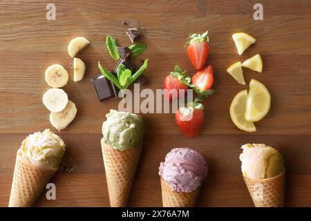 Detail einer Auswahl an Eissorten verschiedener Geschmacksrichtungen mit Früchten jeder Geschmacksrichtung auf Holztisch Stockfoto