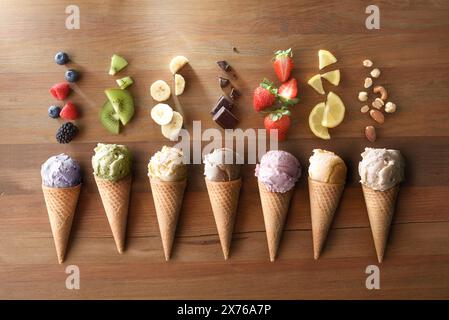 Auswahl an Eissorten mit verschiedenen Geschmacksrichtungen mit Früchten jedes Geschmacksrichtungen auf Holztisch Stockfoto