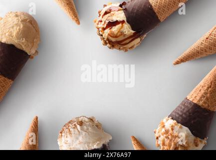 Rahmen mit Eiskegeln verschiedener Geschmacksrichtungen mit Schokoladentegel auf weißem Hintergrund Stockfoto