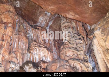 Eine Höhle mit vielen Felsformationen und Stalaktiten, die von der Decke hängen. Die Szene ist geheimnisvoll und beeindruckend. Stockfoto