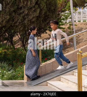 Turkmenische Kinder spielen auf der Steigung neben Treppen, Merv, Turkmenistan Stockfoto