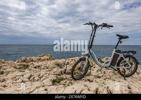 Ein kleines zusammenklappbares elektrisches Touristenfahrrad, erkunden die Küste mit dem Fahrrad, Fahrradtourismus Rovinj Kroatien Stockfoto