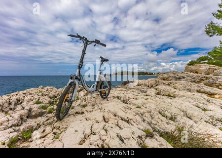 Ein kleines zusammenklappbares elektrisches Touristenfahrrad, erkunden die Küste mit dem Fahrrad, Fahrradtourismus Rovinj Kroatien Stockfoto