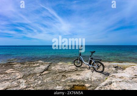 Ein kleines zusammenklappbares elektrisches Touristenfahrrad, erkunden die Küste mit dem Fahrrad, Fahrradtourismus Rovinj Kroatien Stockfoto