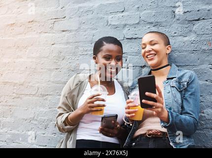 Online, Video und Freunde mit Telefon sehen Post in sozialen Medien in der Stadt auf Kaffeepause oder teilen Klatsch. Glücklich, Leute oder lachen über Witze im Internet Stockfoto