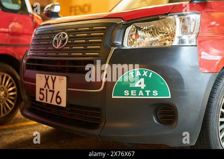 HONGKONG, CHINA - 05. DEZEMBER 2023: Nahaufnahme eines Taxifahrzeugs in Tsim Sha Tsui, Hongkong bei Nacht. Stockfoto