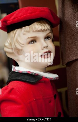 Ein Porträt einer klassischen Kinderpuppe in rot gekleidet Stockfoto