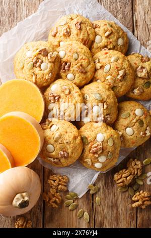 Kürbis-Nuss-Schokoladen-Chip-Cookies Nahaufnahme auf dem Pergament auf dem Holztisch. Vertikale Draufsicht von oben Stockfoto