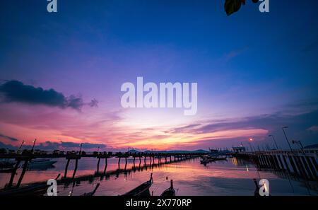 Atemberaubende farbenfrohe Wolken bei Sonnenaufgang über dem Chalong Pier. Szene mit farbenfrohem gelbem Licht durch die Wolken. Verlaufsfarbe. Himmelsstruktur, abstrakte Natur Stockfoto