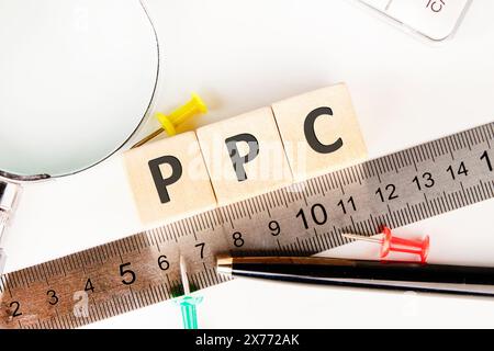 PPC – Zahlen Sie pro Klick, der auf Holzwürfeln neben dem Lineal steht Stockfoto