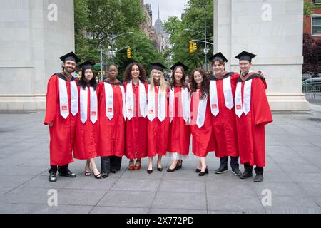 Absolventen der New School, Parsons School of Design posieren in ihren Kappen und roten Kleidern in der Nähe des Bogens im Washington Square Park in Manhattan. Stockfoto