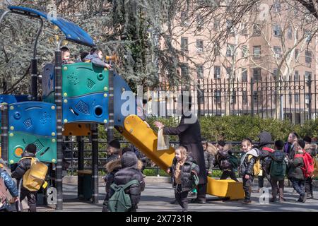 Unter der Aufsicht ihres Rabbiners spielt eine Gruppe junger jüdischer Studenten während der Pause ihrer Jeschiwa auf dem Sobel Playground. In Brooklyn, New York Stockfoto