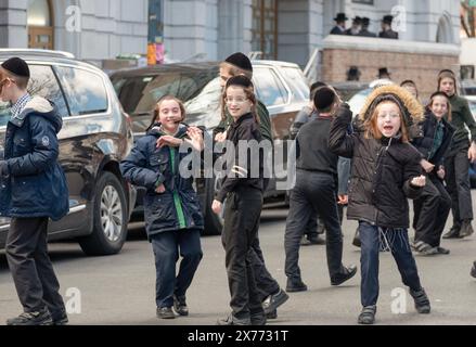 Während der Pause laufen orthodoxe jüdische Jeschiwa-Schüler im aktiven Spiel herum. In Brooklyn, Anfang Frühjahr 2024. Stockfoto