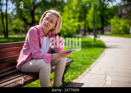 Porträt der Reifen Frau im Park. Sie macht sich Sorgen. Stockfoto