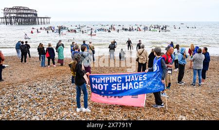 Brighton UK 18th May 2024 - die Surfer gegen Abwasser Protest von Brighton West Pier heute, als Hunderte von Paddelboardern und Schwimmern auf das Meer gehen und sich für Wasserunternehmen einsetzen , um Abwasser in das Meer und die Wasserstraßen um Großbritannien zu pumpen . Credit Simon Dack / Alamy Live News Stockfoto