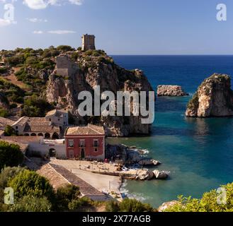 Blick auf die Faraglioni und den Turm Doria über dem Tonnara Di Scopello. Wunderschöne Küstenlandschaft des Dorfes Scopello in Sizilien, Provinz Trapani, Italien Stockfoto