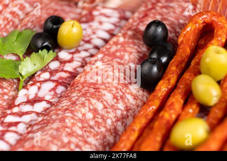 Fleischplatte – Würstchen, Salami und andere Fleischspezialitäten mit Oliven Stockfoto
