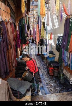 Fès, Marokko - 4. März 2024: Mann entleert Eimer mit Farbstoff im Färberviertel des Marktes in der Medina von Fès Stockfoto