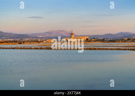 Paceco, Italien - 3. Januar 2024: Blick auf die Windmühle und das Salzflachmuseum von Paceco bei Sonnenuntergang Stockfoto