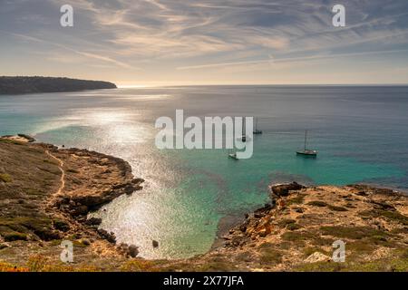 Landschaftsblick auf eine idyllische Bucht bei es Cap Enderrocat im Süden Mallorcas mit Segelbooten vor Anker Stockfoto