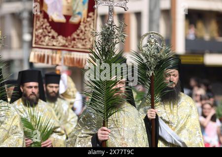 Rumänische orthodoxe Priester, die Palmblätter halten, gehen während einer Palmensonntag-Wallfahrt durch die Straßen von Bukarest. Stockfoto