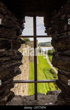 Blick durch einen der Pfeilschlitze in den mittelalterlichen Mauern der nordwalisischen Stadt Conwy Stockfoto