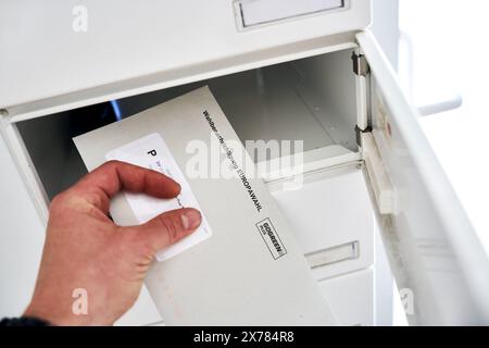 Bayern, Deutschland - 18. Mai 2024: Hand nimmt einen Brief mit der Wahlbenachrichtigung zur Europawahl 2024 aus dem Briefkasten *** Hand holt einen Brief mit der Wahlbenachrichtigung zur Europawahl 2024 aus dem Briefkasten Stockfoto