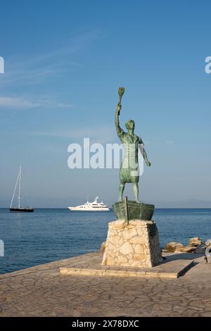 Statue des Hafens von Gaios auf der Insel Paxos in Griechenland, im Hintergrund Boote und Segelschiffe, die im Mittelmeer segeln, vertikaler Bildschirm Stockfoto