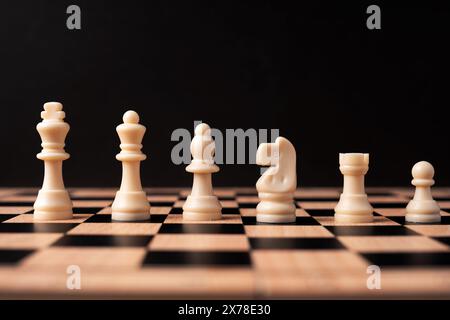 Reihen weißer Schachfiguren auf schwarzem Hintergrund Stockfoto