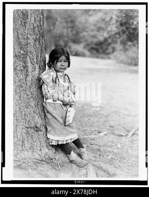 Innocence, ein Umatilla-Mädchen, ein Porträt in voller Länge, stehend am Baum, etwas nach rechts gerichtet, Edward S. Curtis Collection., Curtis Nr. 3300–10., veröffentlicht in: The North American Indian / Edward S. Curtis. Edward S. Curtis, 1907-30, suppl., v. 8, pl. 270.. Indianer von Nordamerika, Oregon, Kinder, 1910. Umatilla-Indianer, Kinder, 1910. , Girls, Oregon, 1910. Stockfoto