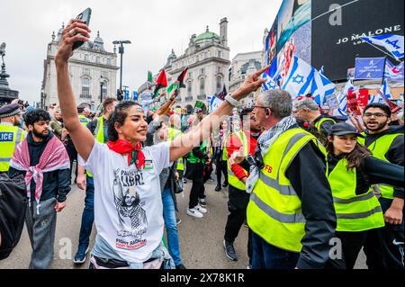 London, Großbritannien. 18. Mai 2024. Der gewaltige marsch übertrifft bei weitem den sehr kleinen Pro-Israel-Gegenprotest an einer Ecke des Piccadilly Circus. Die Polizei hält die beiden Gruppen voneinander getrennt - nationale Demonstration zum Jahrestag der Nakba, als Hunderttausende Palästinenser gezwungen wurden, ihr Land zu verlassen, um Platz für den israelischen Staat zu machen. Der pro-palästinensische Protest rief auch zu einer Waffenruhe auf und stoppte die Bewaffnung Israels. Sie marschierte von der BBC nach Whitehall. Das Volk reagiert weiterhin auf den israelischen Angriff in Gaza. Der Protest wurde von Stop the war organisiert Stockfoto
