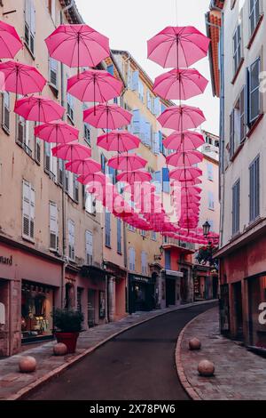 Grasse, Frankreich - 23. Juli 2023: Berühmte pinkfarbene Regenschirme schmücken die zentralen Straßen von Grasse Stockfoto