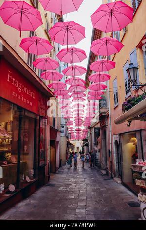 Grasse, Frankreich - 23. Juli 2023: Berühmte pinkfarbene Regenschirme schmücken die zentralen Straßen von Grasse Stockfoto