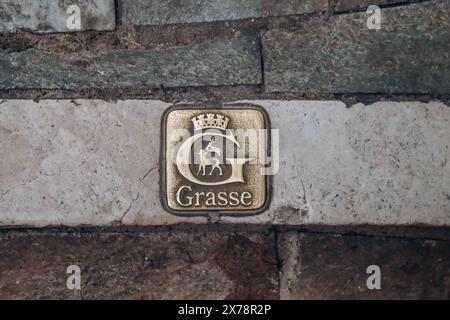 Grasse, Frankreich - 23. Juli 2023: Emblem von Grasse auf dem Bürgersteig im Stadtzentrum Stockfoto