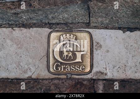 Grasse, Frankreich - 23. Juli 2023: Emblem von Grasse auf dem Bürgersteig im Stadtzentrum Stockfoto