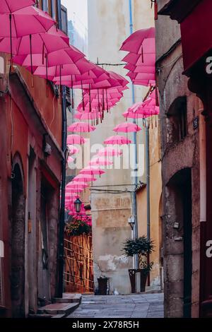 Grasse, Frankreich - 23. Juli 2023: Berühmte pinkfarbene Regenschirme schmücken die zentralen Straßen von Grasse Stockfoto