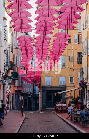 Grasse, Frankreich - 23. Juli 2023: Berühmte pinkfarbene Regenschirme schmücken die zentralen Straßen von Grasse Stockfoto