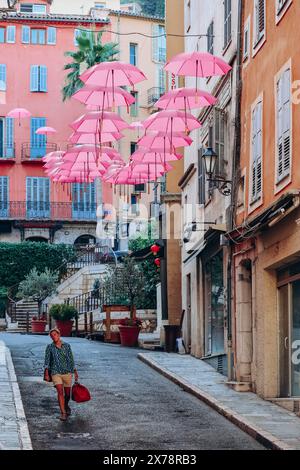 Grasse, Frankreich - 23. Juli 2023: Berühmte pinkfarbene Regenschirme schmücken die zentralen Straßen von Grasse Stockfoto