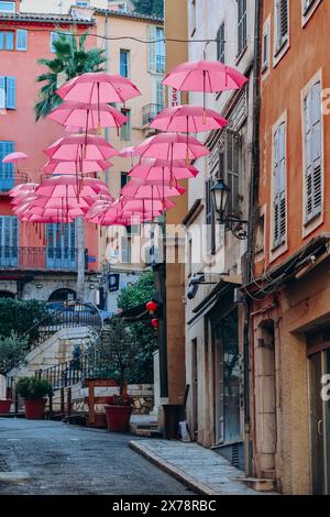 Grasse, Frankreich - 23. Juli 2023: Berühmte pinkfarbene Regenschirme schmücken die zentralen Straßen von Grasse Stockfoto