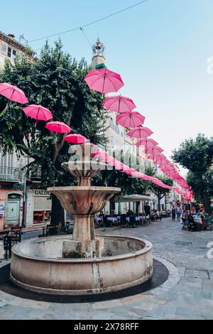Grasse, Frankreich - 23. Juli 2023: Berühmte pinkfarbene Regenschirme schmücken die zentralen Straßen von Grasse Stockfoto