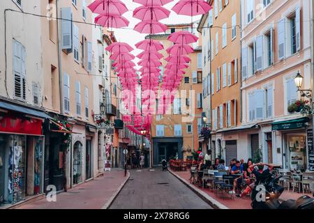 Grasse, Frankreich - 23. Juli 2023: Berühmte pinkfarbene Regenschirme schmücken die zentralen Straßen von Grasse Stockfoto