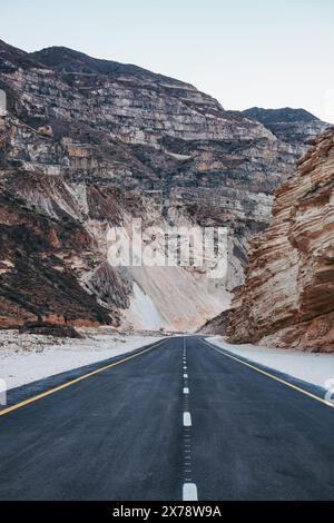 Die leere Mountain Road schlängelt sich bei Sonnenuntergang durch einen Canyon im ländlichen Salalah im südlichen Oman Stockfoto