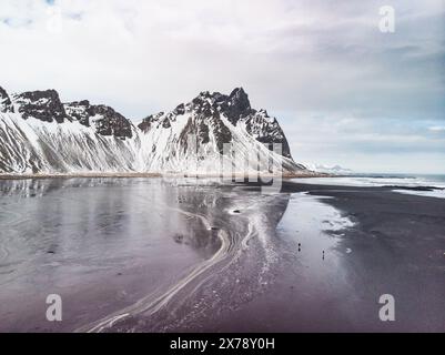 Schneebedeckte Vestrahorn-Berge spiegeln sich im eisigen Wasser am Stokksnes Beach im Südosten Islands. Stockfoto