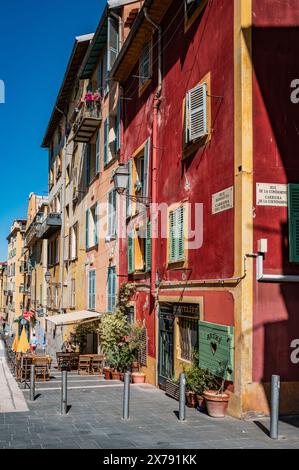 Alte traditionelle Häuser in verschiedenen hellen Farben entlang der engen Straße in der Altstadt von Nizza, Cote d'Azur, Frankreich Stockfoto