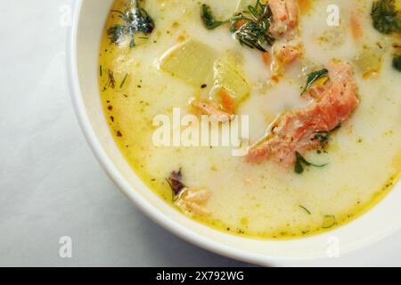 Finnische Sahnesuppe mit Lachs, Kartoffeln, Zwiebeln und Karotten in einer Schüssel auf dem Holztisch, selektiv fokussiert Stockfoto