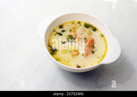 Finnische Sahnesuppe mit Lachs, Kartoffeln, Zwiebeln und Karotten in einer Schüssel auf dem Holztisch, selektiv fokussiert Stockfoto