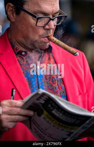 Baltimore, Usa. Mai 2024. Ein Mann raucht eine Zigarre und überlegt seine Wetten auf dem Pimlico Race Course in Baltimore, Maryland am Samstag, den 18. Mai 2024. Foto: Bonnie Cash/UPI Credit: UPI/Alamy Live News Stockfoto